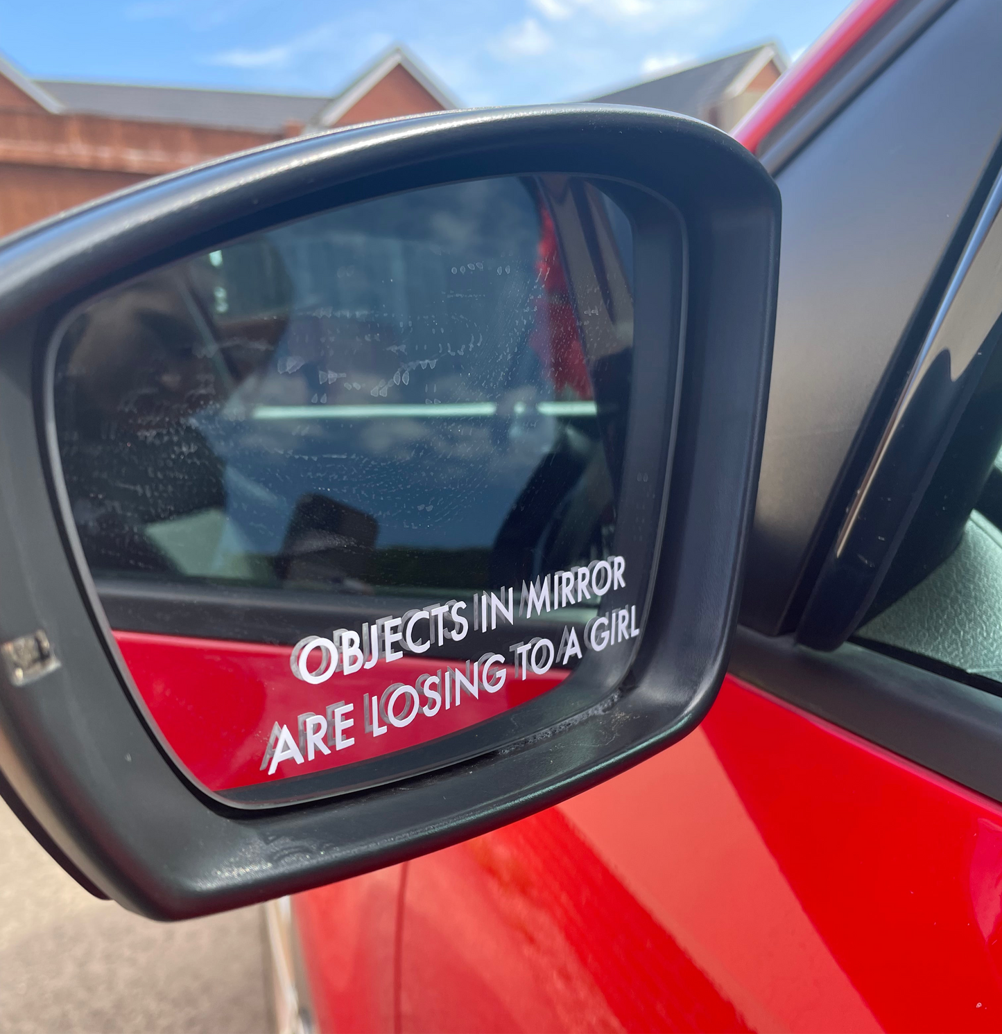 ‘Objects in mirror are losing to a girl’ sticker